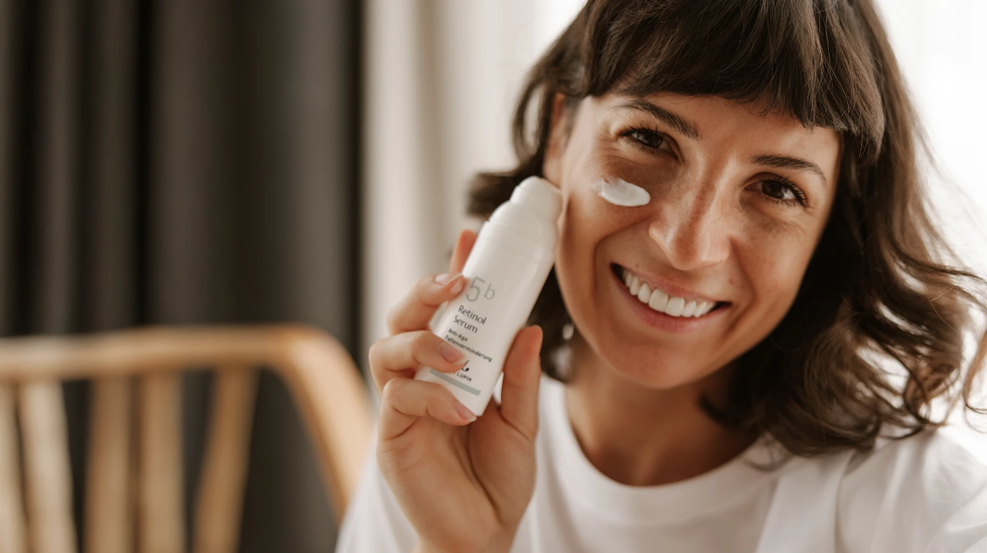 Frau hält Pflegecreme ans Gesicht – Kosmetikstudio Augsburg für strahlende Haut